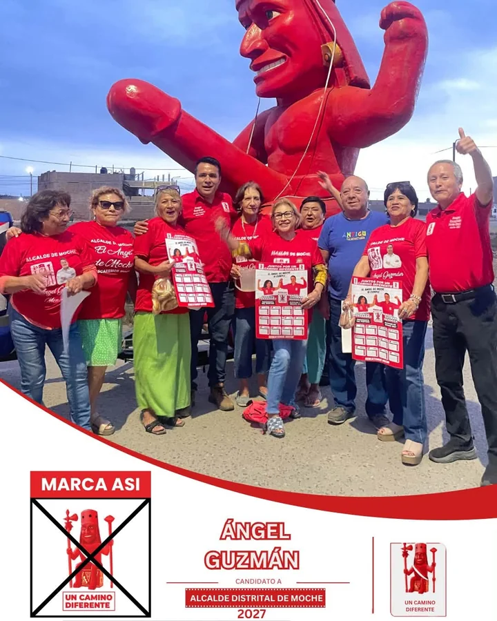Ángel Guzmán Mendoza junto a un grupo de personas frente a una escultura roja, en una fotografía de campaña.